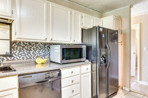 A kitchen with white cabinets, a stainless steel refrigerator, a microwave, and a dishwasher. - 2 Mi to Fort Sill: Quiet Family Retreat w/ Yard (Lawton)