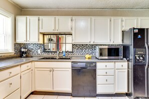 A kitchen with white cabinets, a black refrigerator, a microwave, and a dishwasher. - 2 Mi to Fort Sill: Quiet Family Retreat w/ Yard (Lawton)
