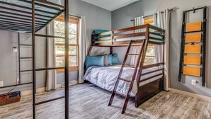 A bunk bed room with a ladder, wooden floor, and a window with curtains. - Stars & Sunsets! Door Peninsula Retreat w/ Deck (Egg Harbor)