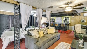 A cozy living room with a grey sofa, a coffee table, and a ceiling fan. - Convenient Studio w/ Private Bar in Odessa (Odessa)