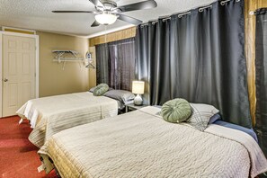 A hotel room with two beds, a ceiling fan, a lamp, and a window with curtains. - Convenient Studio w/ Private Bar in Odessa (Odessa)
