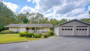 A two-story house with a front porch, a garage, and a well-maintained lawn.