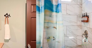 A bathroom with a wooden door, a towel hanging on a hook, a shower curtain with a fish pattern, and toiletries on the wall.