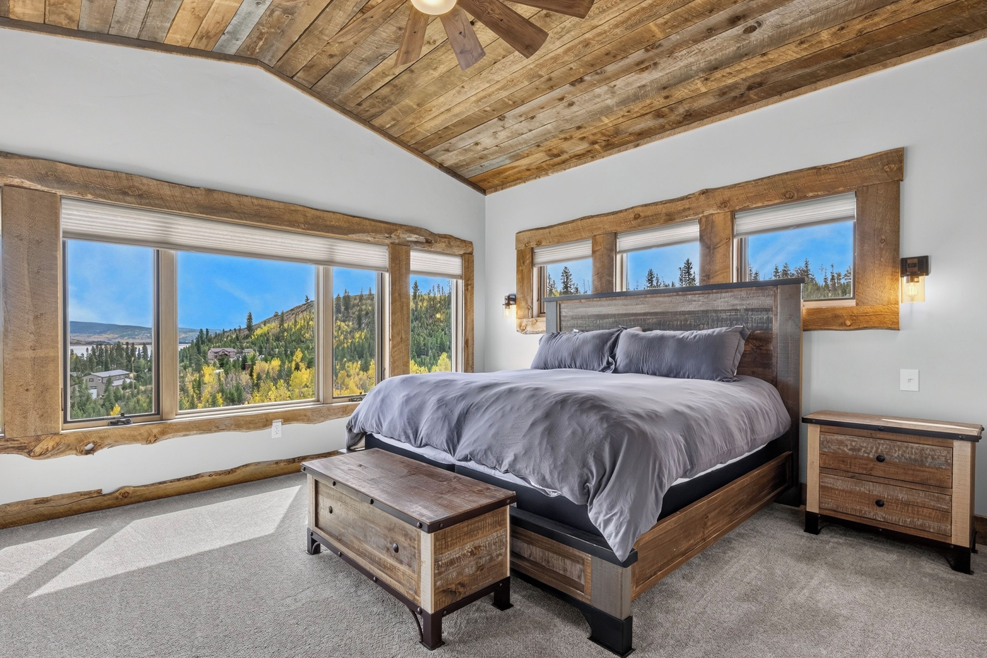 Wake up to aspen groves and mountain scenery framed by reclaimed wood. Your bedroom features a plush king bed beneath handcrafted beams, with windows on two sides bringing in natural light and forest views.