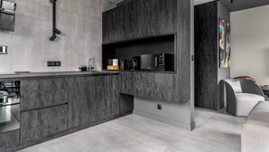 A modern kitchen with dark marble countertops, built-in appliances, and a minimalist design. - AS HOME Niegaleria (Wrocław)
