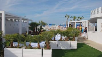 En la playa, sillas reclinables de playa, sombrillas