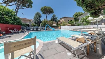 Una piscina al aire libre de temporada, sillones reclinables de piscina