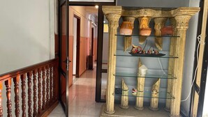 A hallway with a wooden railing, a glass display case with pottery, and a tiled floor. - Beautiful house, very comfortable, fully equipped, 500m from the beach, close to everything✅ (Boumerdes)
