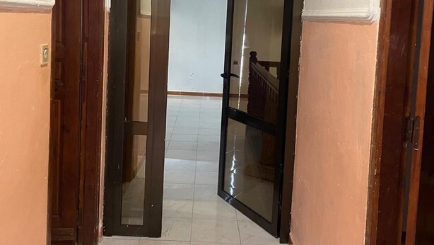 A hallway with a tiled floor, wooden doors, and a white ceiling with decorative molding. - Beautiful house, very comfortable, fully equipped, 500m from the beach, close to everything✅ (Boumerdes)