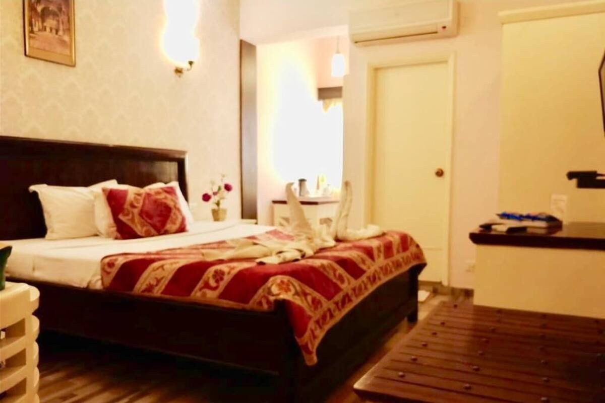 Ein Hotelzimmer mit einem Bett, einem Nachttisch und einer hölzernen Bank.