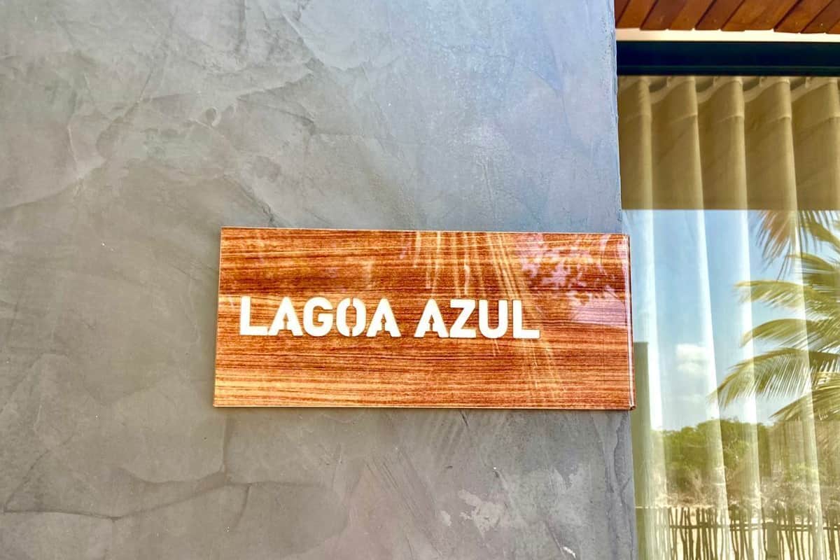 A wooden sign with the text "LAGOA AZUL" mounted on a textured wall.