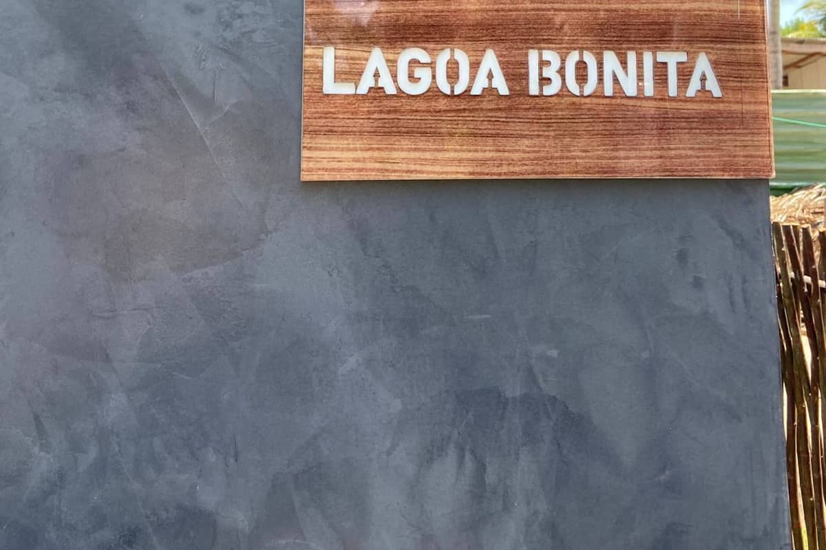 A sign with the text "LAGOA BONITA" mounted on a grey wall.