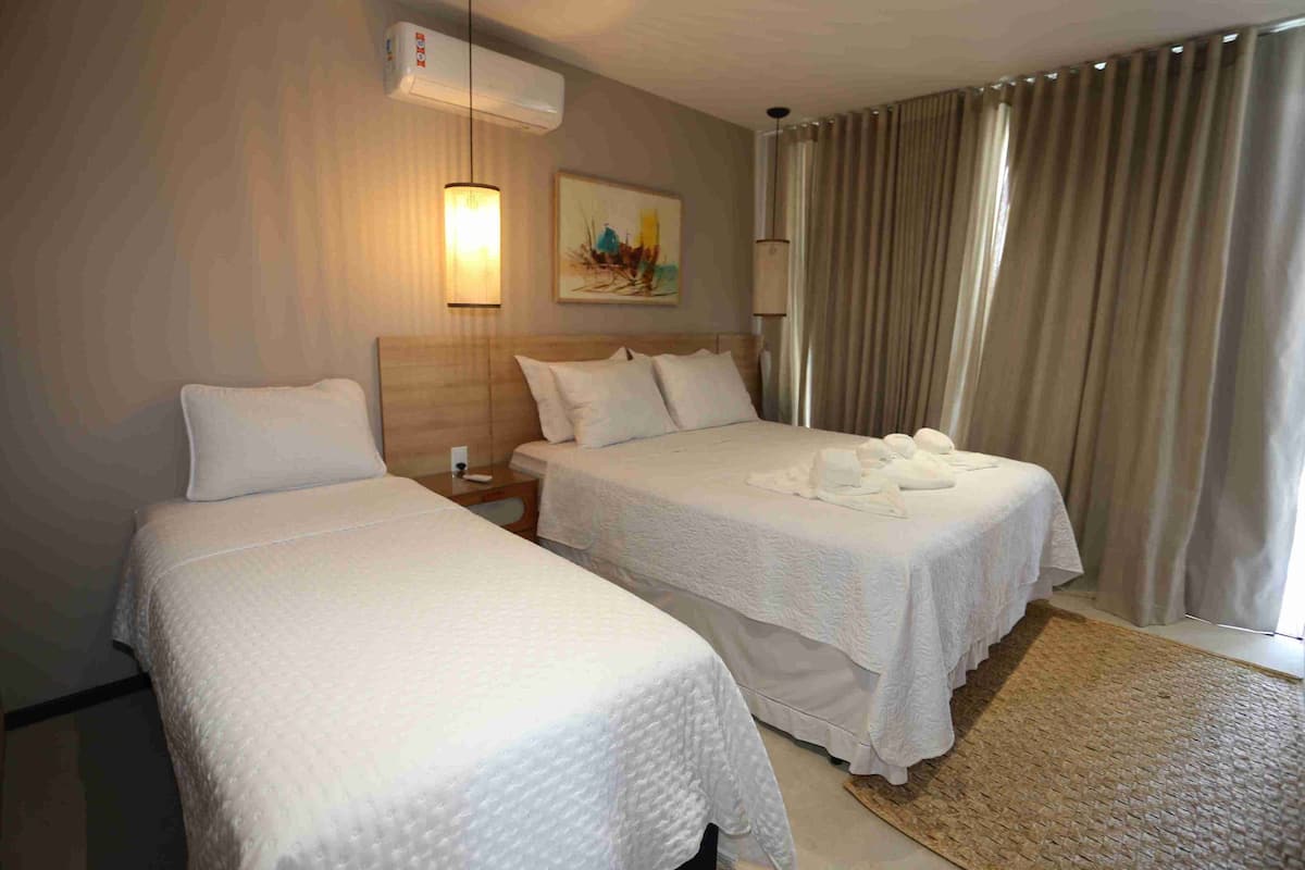 Habitación triple Deluxe, varias camas, vistas a la piscina | Cortinas opacas, tabla de planchar con plancha, wifi gratis