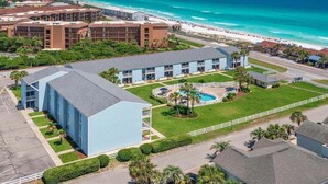 Un hôtel doté d’une piscine, entouré d’une clôture et situé près d’une plage.