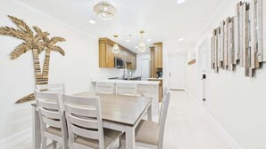 Une cuisine moderne avec des meubles en bois, un îlot central et des luminaires suspendus.