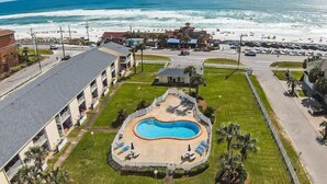 Vue aérienne d’un hôtel doté d’une piscine, d’un accès à la plage et offrant une vue sur l’océan.