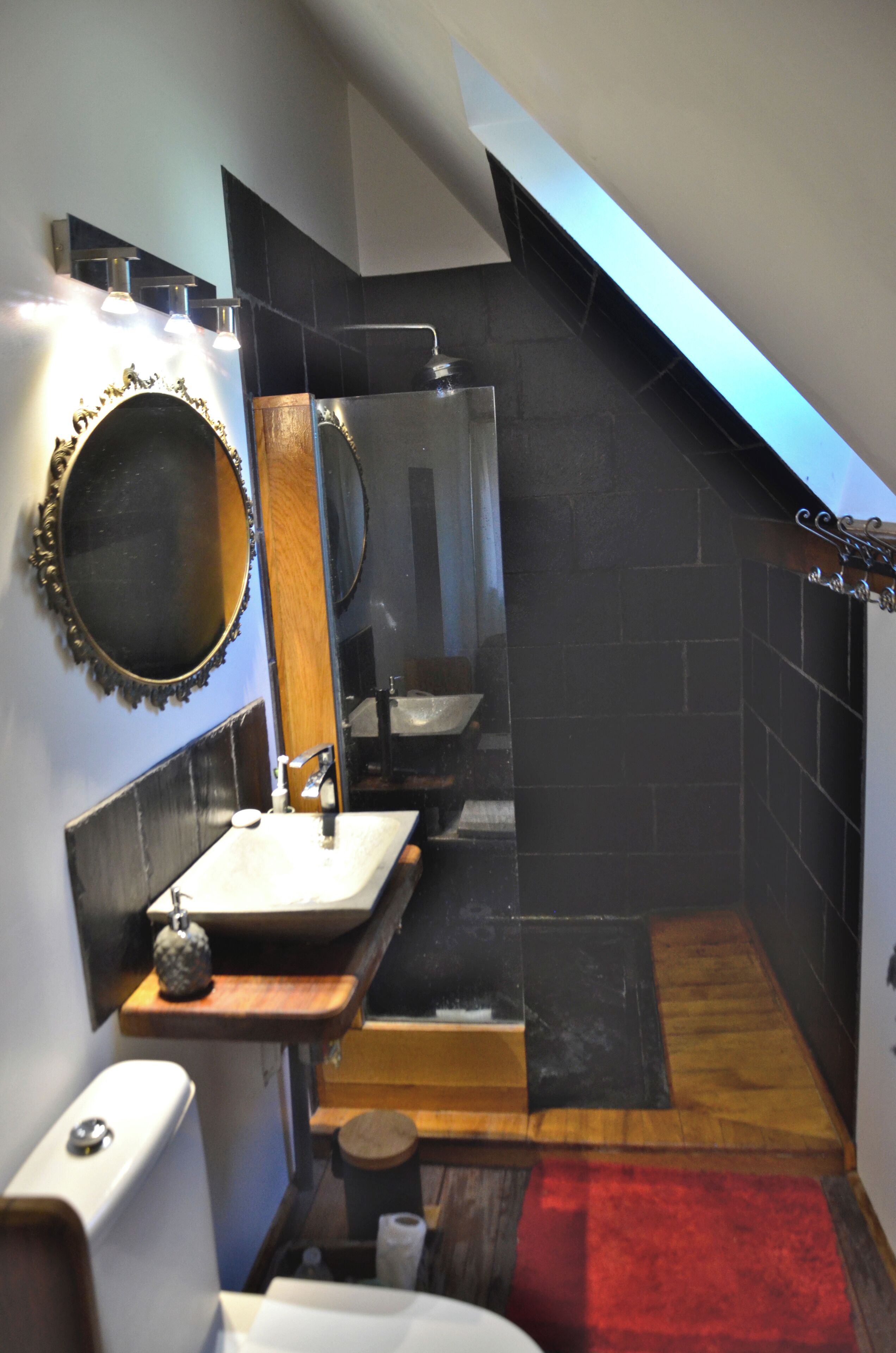 Une salle de bain moderne avec un meuble-lavabo, un miroir et un espace douche.