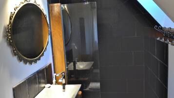 Une salle de bain moderne avec un meuble-lavabo, un miroir et un espace douche.