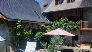 A backyard with a swimming pool, wooden deck, and outdoor furniture. - Les Chatougoulis (Bordes-Uchentein)