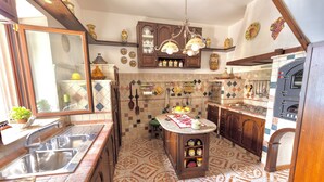 Una cocina con una isla central, pileta doble, armarios de madera y horno empotrado.