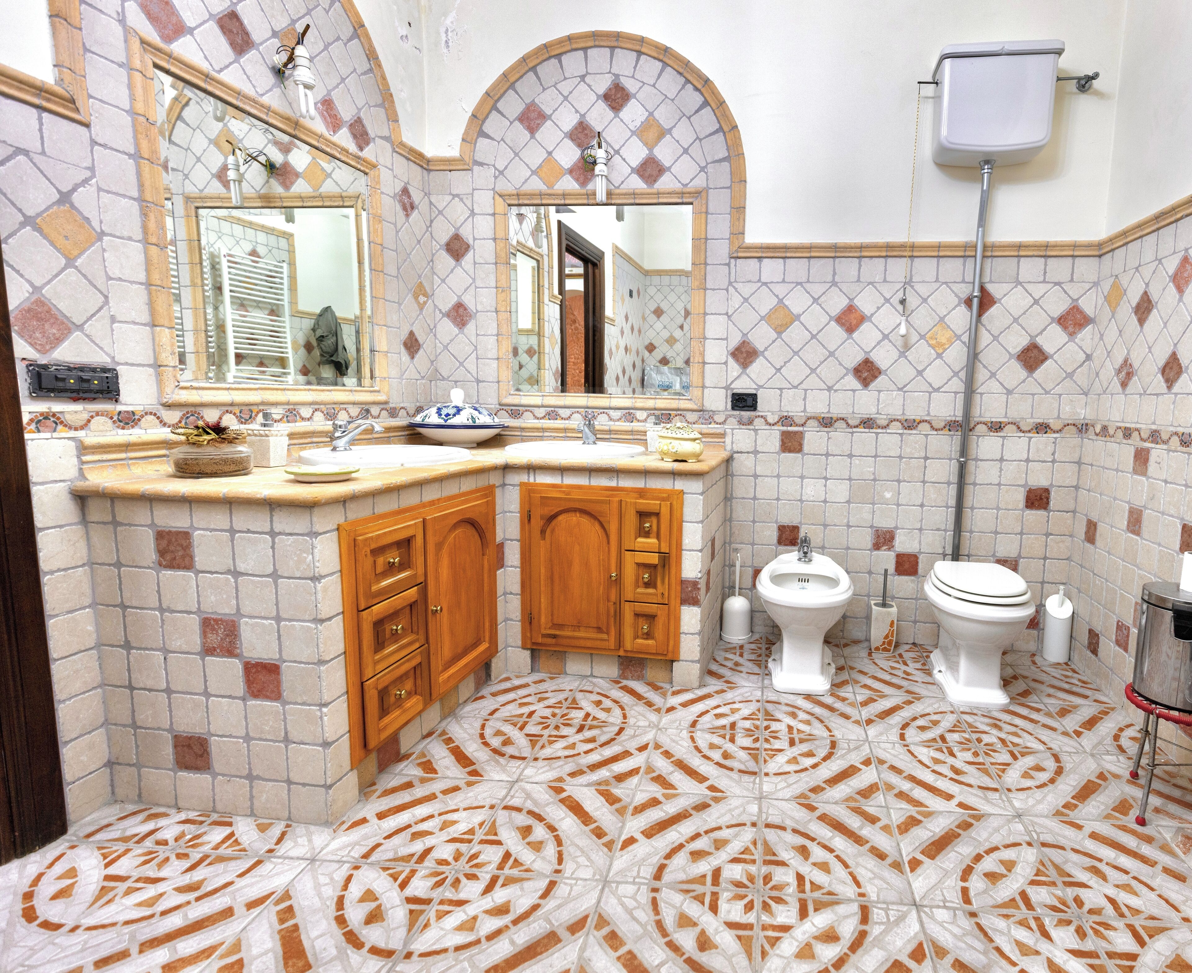 Une salle de bain avec deux lavabos, des meubles en bois, des toilettes et un espace douche.