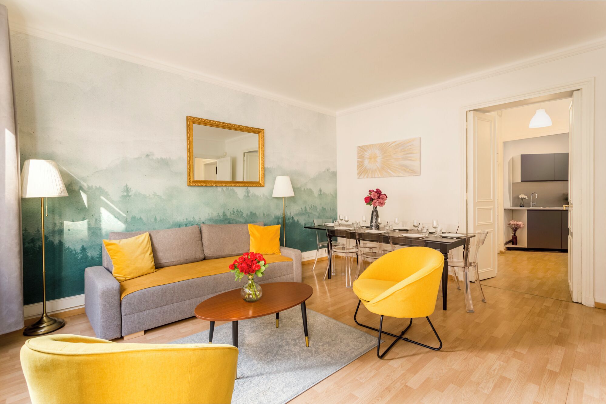 Un salon avec un canapé, une table basse et une table à manger dressée pour six personnes.