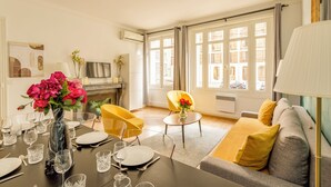 Una sala moderna con comedor, chimenea y ventanas amplias con cortinas.