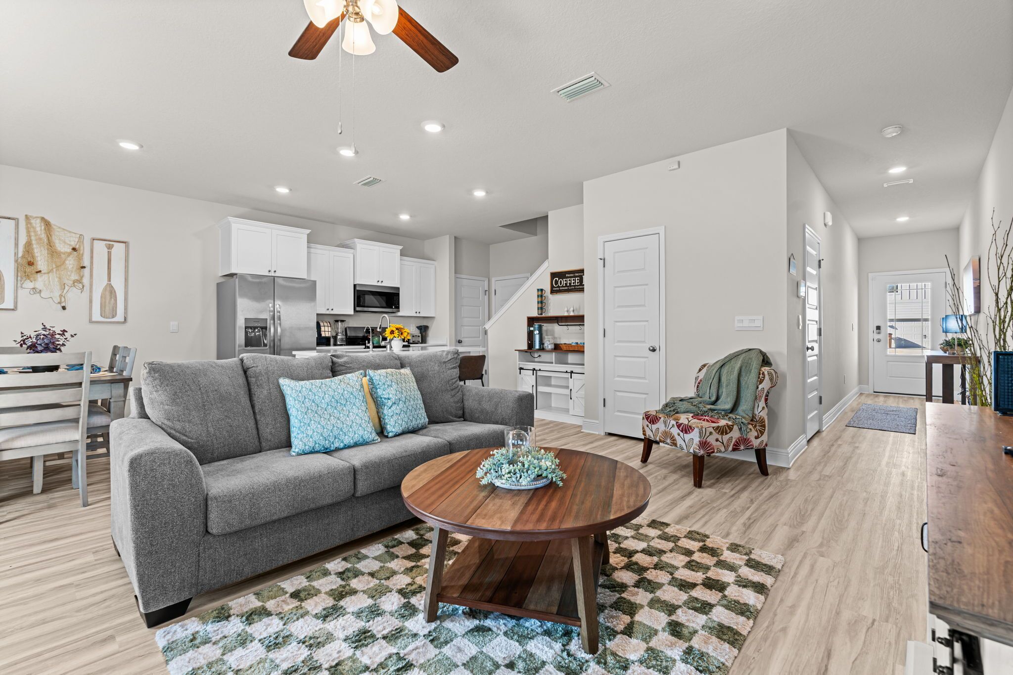 A modern living room with a gray sofa, wooden coffee table, and a patterned rug.