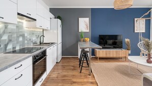 Eine moderne Küche mit weißen Schränken, einem eingebauten Backofen und einer Glasküchenrückwand.