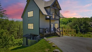 A two-story house with a balcony, a staircase, and a small deck. - Smoky Blue Haven 3 Bedroom Cabin (Sevierville)