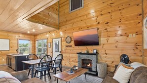 A log cabin interior with a dining area, fireplace, and cozy seating. - Smoky Blue Haven 3 Bedroom Cabin (Sevierville)