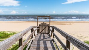 A wooden boardwalk leading to a beach with a clear view of the ocean and distant mountains. - Casa Azul 3 Bedroom Home (Port Bolivar)
