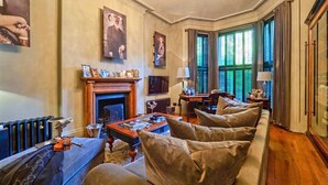 A traditional living room with a fireplace, a sofa set, a coffee table, and a television. - Holland Park Classic High Ceilings Luxury 2 Bed (London)