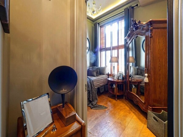 A cozy room with a bed, a small table, and a mirror. - Holland Park Classic High Ceilings Luxury 2 Bed (London)