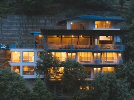 Un edificio de varios pisos con balcones, ventanas grandes y fachada de piedra.