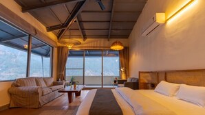 A bedroom with a large bed, a sofa, a small table, and a window with curtains. - Over The World (Kosiyakutoli)