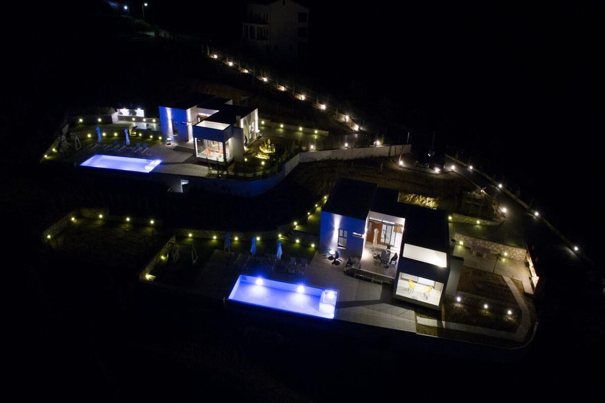 Un hôtel à plusieurs étages doté d’espaces extérieurs aménagés et de chemins éclairés.