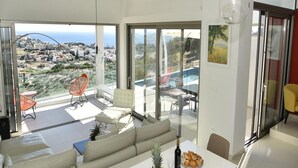 Un salon moderne doté d’une grande porte vitrée donnant sur un balcon avec vue sur la ville.