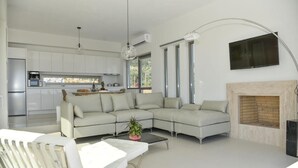 Un salon moderne avec un canapé d’angle, une table basse et une cheminée.