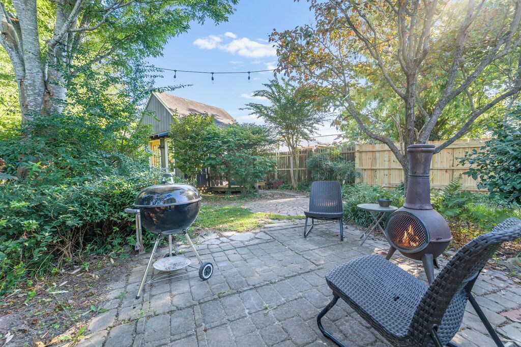 A backyard with a grill, a fire pit, and outdoor seating.