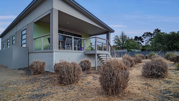 A modern two-story house with a covered porch and a small staircase leading to a deck. - Long Island Retreat: Pelican. The Perfect Riverside Family Getaway. (Murray Bridge)