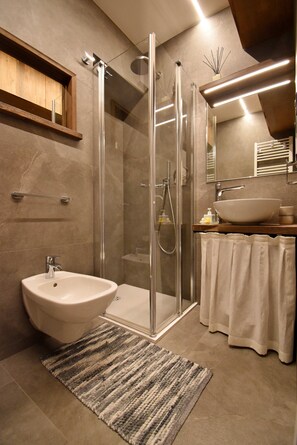 Chuveiro, secador de cabelo, bidê, toalhas de banho