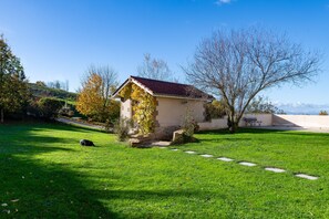 A small building with a red roof, surrounded by a grassy area with a stone path leading to it. - Gîte la Combe Verte – Renovated Farmhouse with Indoor Pool (Claveyson)