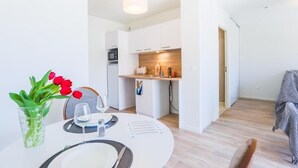 A modern kitchen with white cabinets and a wooden countertop.
