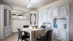 A dining area with a table, chairs, and a chandelier. There are cabinets with glass doors and a mirror above the table. - Villa 'Giovanna' with Private Pool, Wi-Fi and Air Conditioning (sorso)