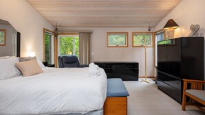 A bedroom with a bed, a bench, a TV, and a dresser. - Lakeside Escape | 5BR | Hot Tub | Family Friendly (Traverse City)