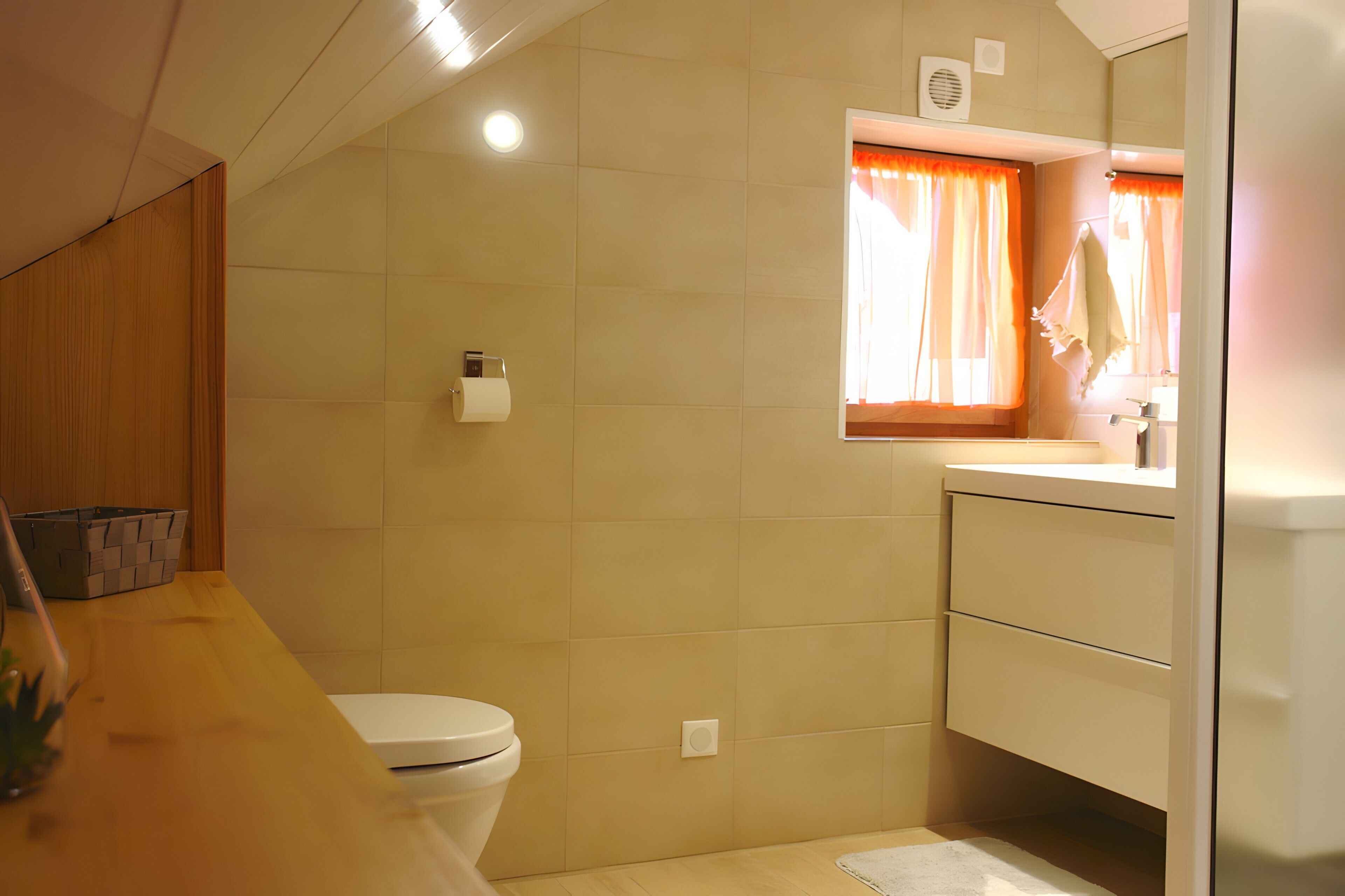 Ein Badezimmer mit Toilette, Waschbecken, Spiegel und einem Fenster mit Vorhängen.