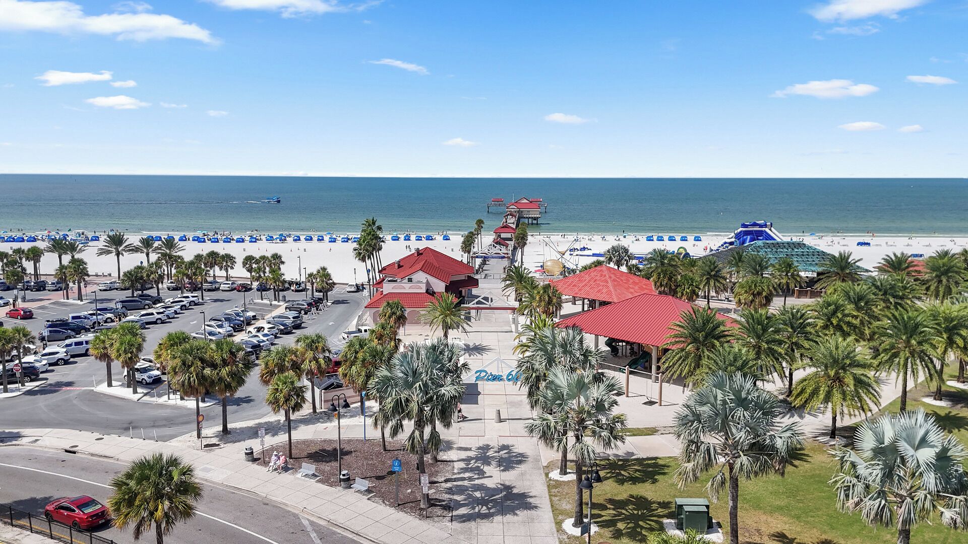 A coastal hotel with a parking lot, beach access, and a view of the ocean.