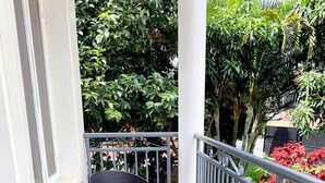 A balcony with two wicker chairs and a small round table, surrounded by a metal railing and potted plants. - ITUNDA NICE RESIDENCE KIGALI (Kigali)