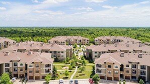 A residential complex with multiple apartment buildings, a central green space, and a parking area.